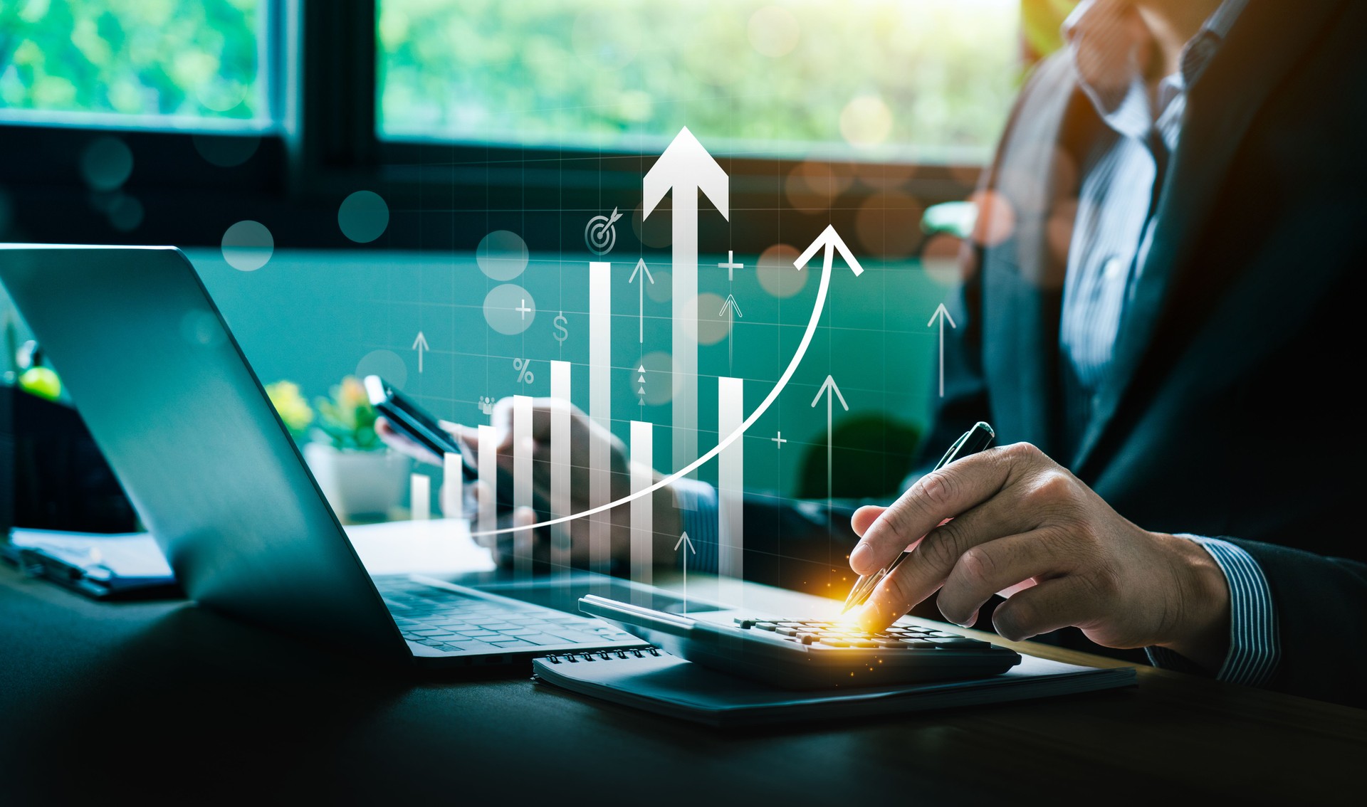 Business Professional Using Calculator and Laptop to Analyze Financial Growth with Rising Bar Graph Depicting Increasing Profits, Economic Trends, and Strategic Planning for Future Investment